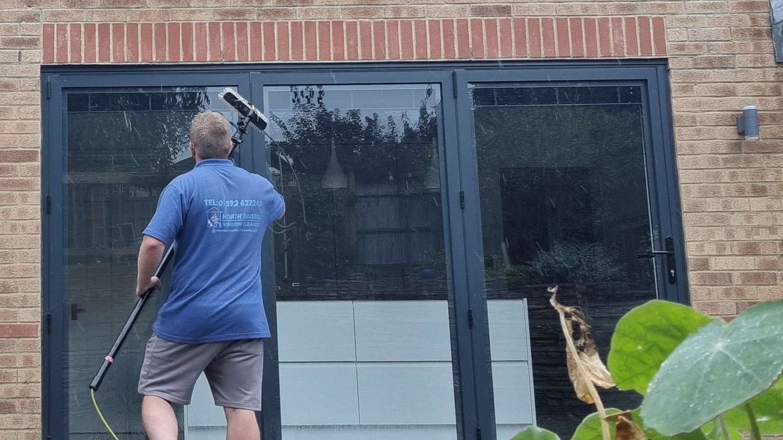 an image of a window cleaner holding a water-fed pole